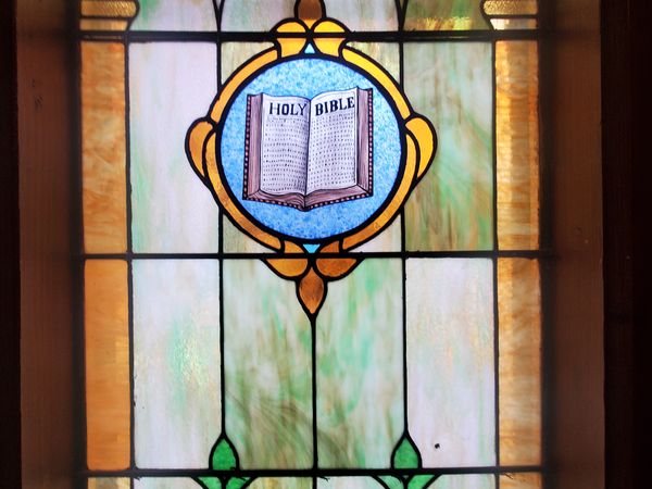 Stained glass window with an open Bible design